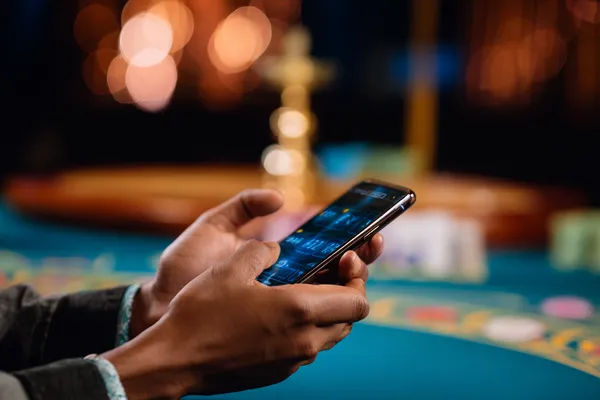 A player using their smartphone during a festive local event, representing 5666BEF’s fully mobile-friendly casino.